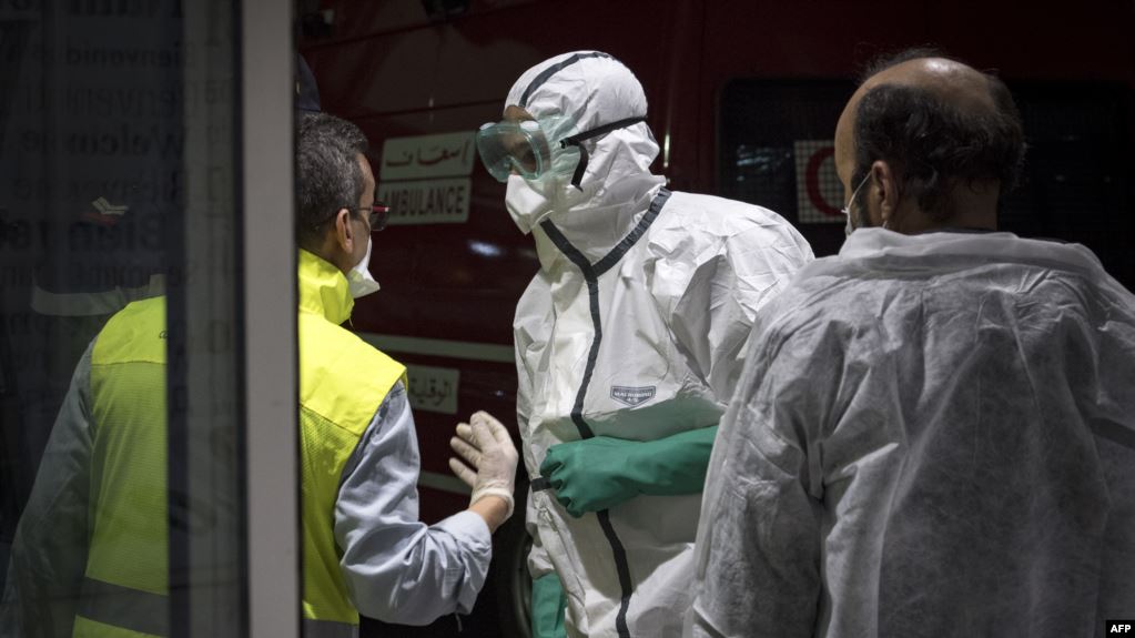 عاملو صحة في مطار محمد الخامس يفحصون مسافرين قادمين من إيطاليا. وكانت أول إصابتين بفيروس كورونا في المغرب قد سجلتا في مواطنين قدما من إيطاليا