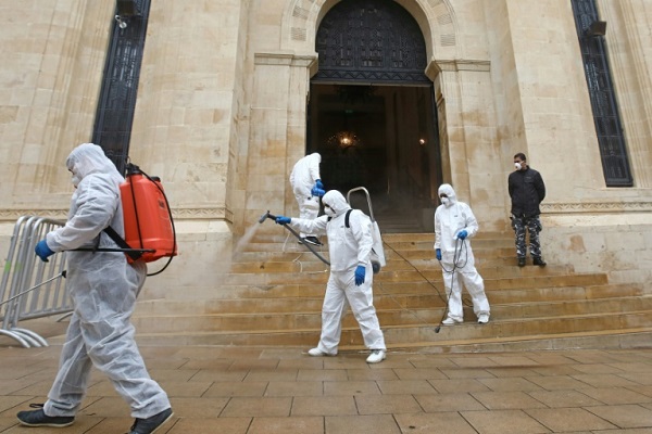 فريق صحي يعقّم مدخل البرلمان اللبناني في وسط بيروت في 10 مارس سعيا لمنع انتشار فيروس كورونا