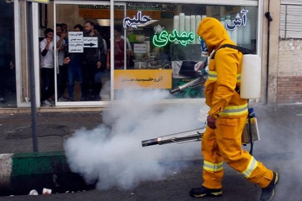 عامل إطفاء يعقم شارعاً في العاصمة الإيرانية 