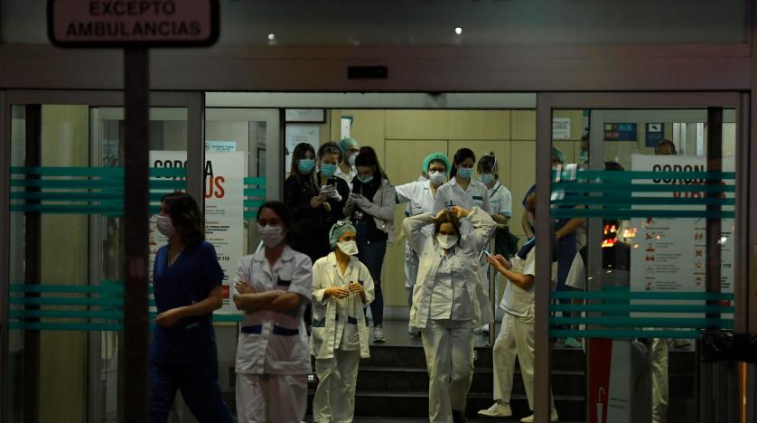 طواقم رعاية صحية يتعاملون مع أزمة كورونا في مدخل مستشفى مؤسسة خيمينيز دياز في مدريد (أ.ف.ب)