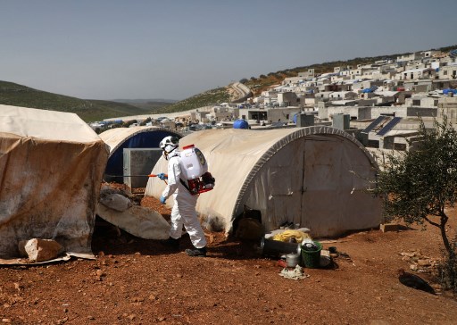 الدفاع المدني السوري يقوم بتعقيم خيم للاجئين قرب الحدود السورية التركية