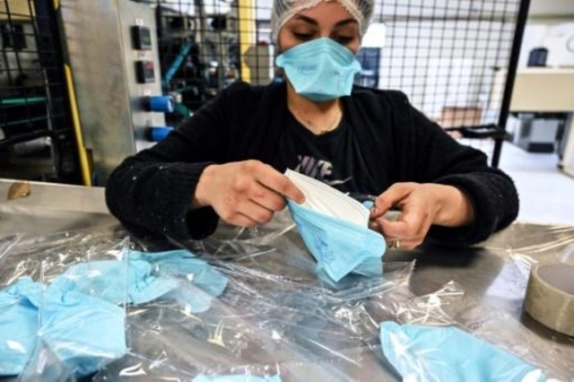 عاملة تجهز طلبية كمامات وقائية في مصنع وسط فرنسا، 28 شباط/فبراير 2020.