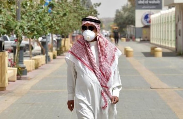 سعودي يرتدي كمامة واقية يسير في أحد شوارع الرياض