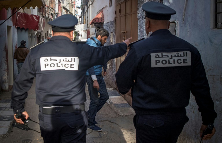عناصر من قوات الأمن المغربية في أحد شوارع الرباط يدعون الناس الى التزام الحجر الصحي في منازلهم في 27 مارس 2020