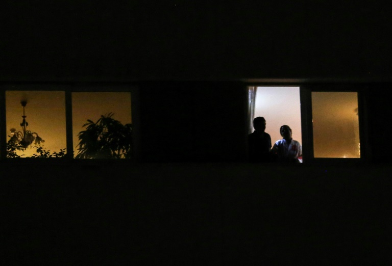 زوجان ينظران من النافذة خلال إجراءات العزل المنزلي المفروضة في إيران في 7 أبريل 2020