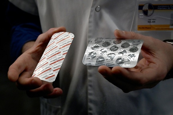 رجل يحمل أقراص كلوروكين وهيدروكسي كلوروكين في معهد طبي في مرسيليا في 26 فبراير 2020