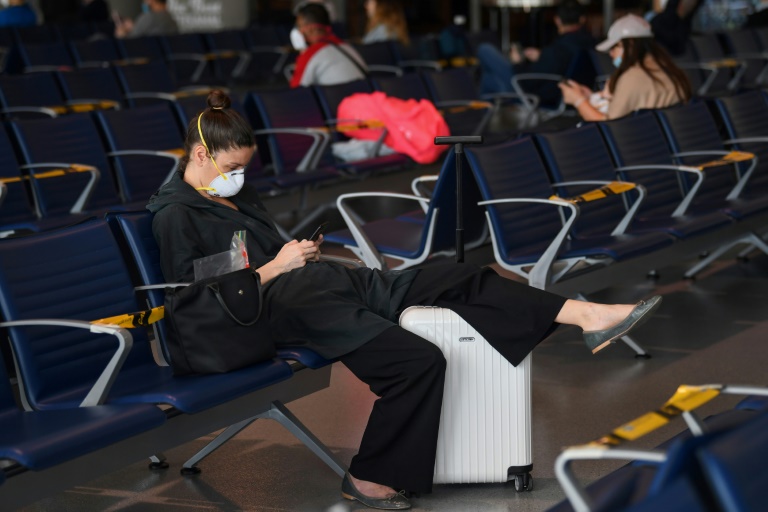 مسافرون متوجهون إلى فرانكفورت في انتظار طائرتهم في مطار دبي الدولي في 6 أبريل 2020