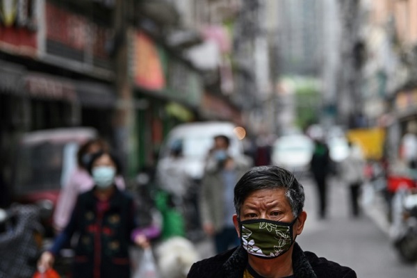 رجل يرتدي قناعاً واقياً في شارع في مدينة ووهان في وسط الصين في 8 أبريل 2020