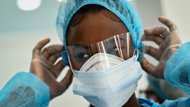 صورة توضيحية: موظفة طبية تعدل قناع الوجه الواقي لها في مركز طبي في باريس، 1 أبريل 2020 (BERTRAND GUAY / AFP)