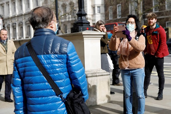 سائحان يضعان قناعا واقيا على الوجه في لندن
