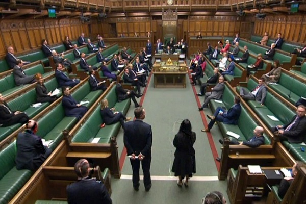 لقطة من الشاشة نشرتها وحدة التسجيل في البرلمان البريطاني تُظهر نواباً يجلسون في مجلس العموم لفي لندن في 25 مارس 2020