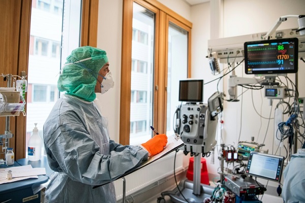 ممرضة ترتدي بزة وقناعاً واقيين في غرفة مريض في مستشفى في سولنا قرب ستوكهولم في السويد في 19 أبريل 2020