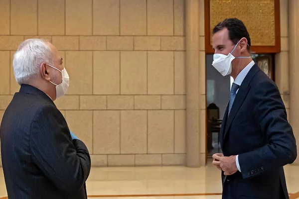 الأسد واضعاً كمامة ومستقبلاً وزير الخارجية الايراني محمد جواد ظريف