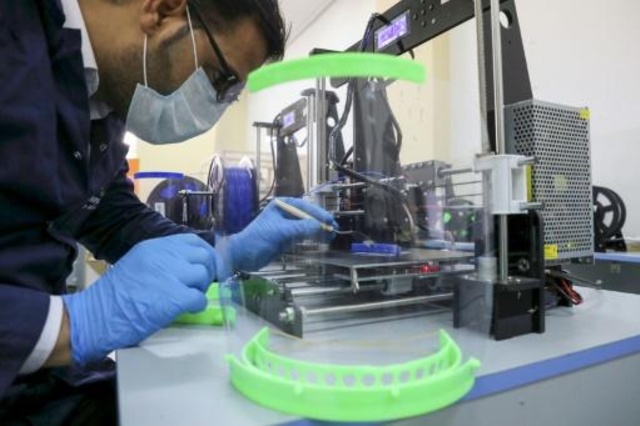 مهندس فلسطيني في جامعة القدس يراقب إحدى مراحل تصنيع جهاز تنفس من صنع محلي للاستخدام في الوقاية من فيروس كورونا 