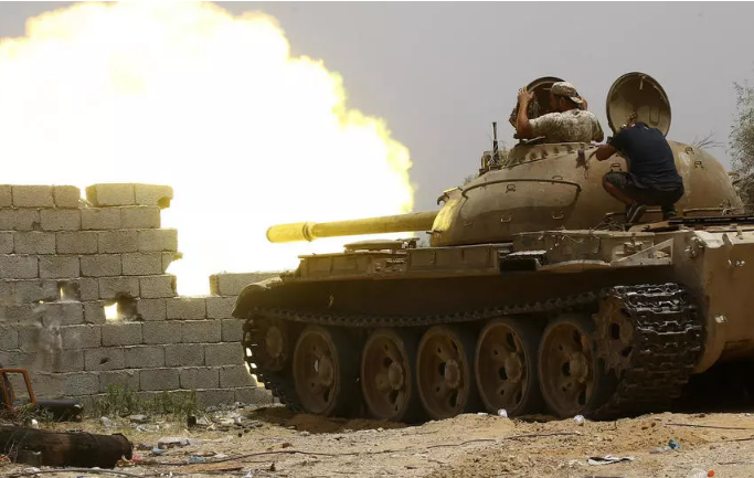 مقاتلون ليبيون موالون لحكومة الوفاق الوطني يطلقون النار من دبابة أثناء القتال ضد القوات الموالية للمشير خليفة حفتر، في جنوب العاصمة الليبية طرابلس، في 13 حزيران/يونيو2019. 