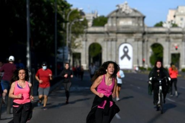 ممارسو رياضة الركض أمام بوابة الكالا في مدريد وبدت عليها شارة الحداد في 2 ايار/مايو 2020.