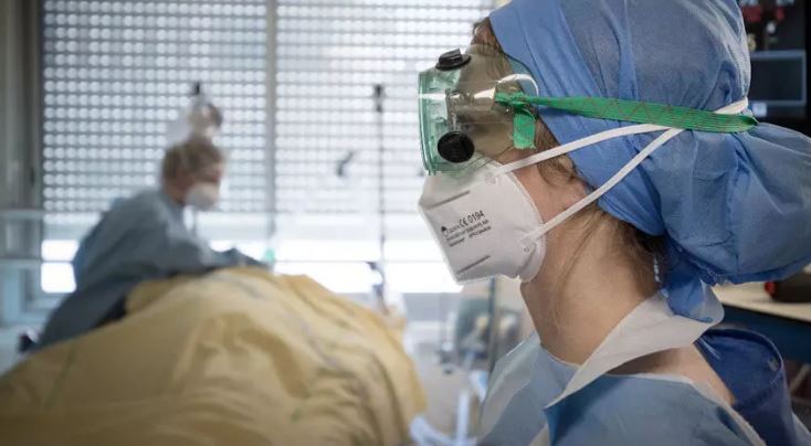 الطاقم الطبي يتكفل بمريض مصاب بفيروس كورونا، وحدة العناية المركزة في مستشفى Lariboisière في باريس. 27 أبريل/نيسان 2020. © أ ف ب.