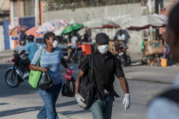 مارة يضعون أقنعة للحماية من فيروس كورونا المستجد في هايتي