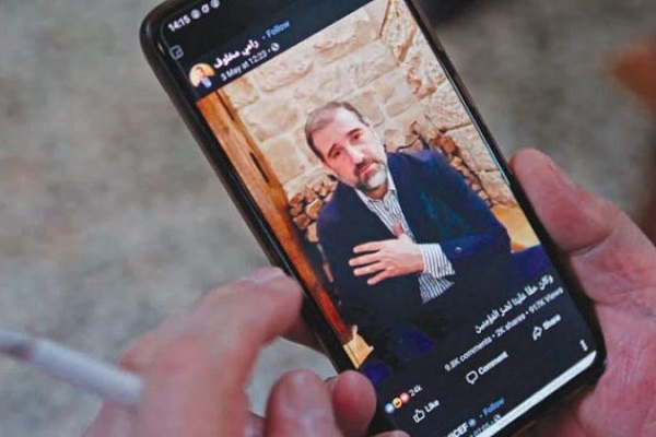 رجل يشاهد فيديو نشره رامي مخلوف على صفحته في فيسبوك
