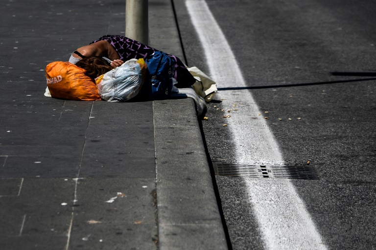 صورة من الارشيف لمشردة تنام على الرصيف قرب محطة ترميني في روما في 4 ايار/مايو 2020