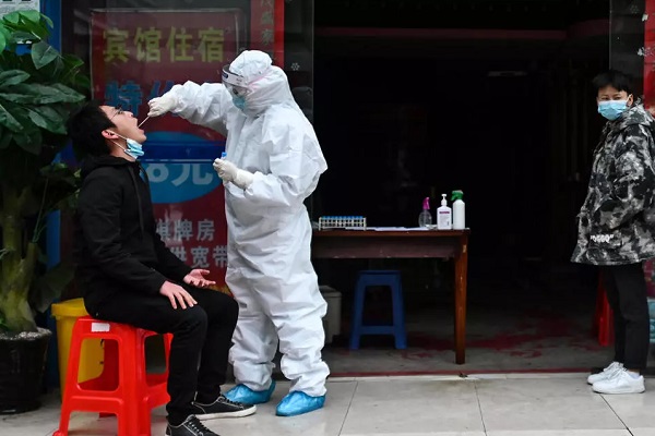صينيون ينتظرون في صف لإجراء فحص الكشف عن الإصابة بفيروس كورونا في ووهان