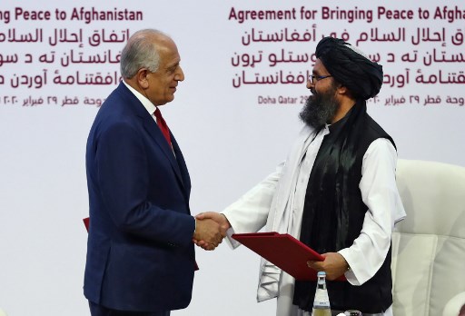 المبعوث الأميركي إلى أفغانستان زلماي خليل زاد مع ممثل طالبان خلال توقيع اتفاق الدوحة