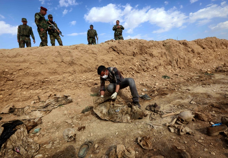 عراقي يبحث عن رفات أيزيديين قتلهم تنظيم الدولة الإسلامية بسنجار شمال غرب العراق، في 03 شباط/فبراير 2015