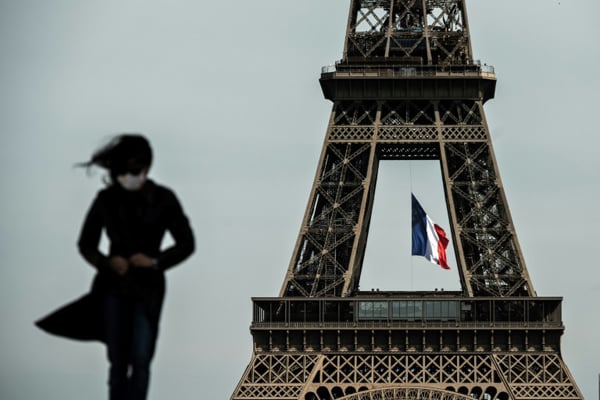 امرأة ترتدي قناعًًا واقيًا أمام برج إيفل في باريس في 11 مايو 2020