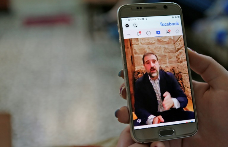 تشاهد عبر تطبيق فيسبوك فيديو لرامي مخلوف على شاشة الهاتف في دمشق في 11 مايو 2020