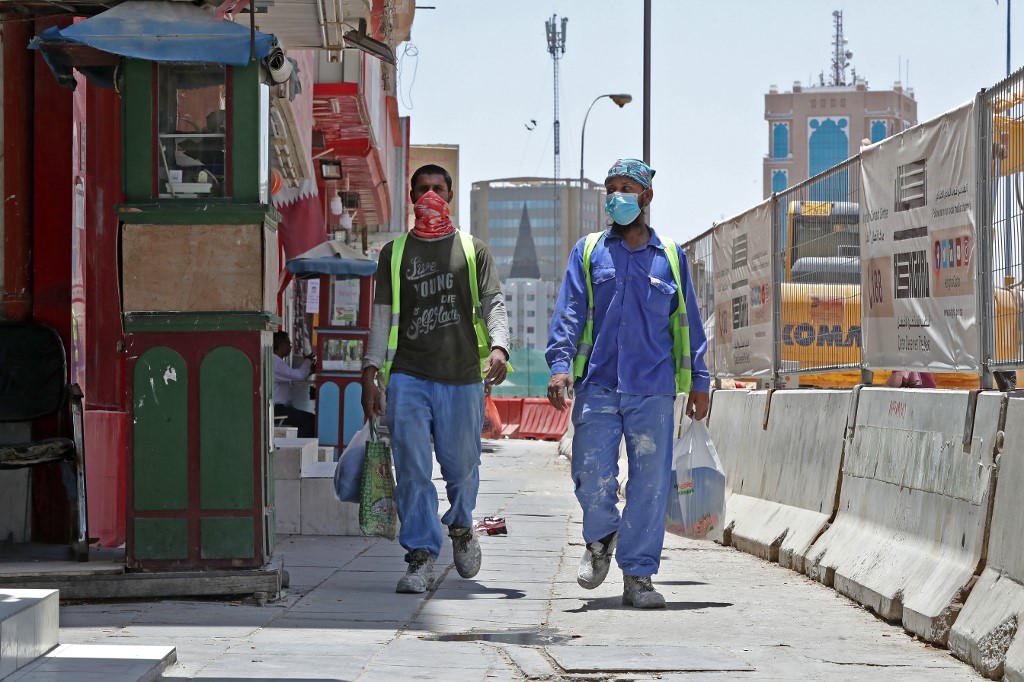 عاملان أجنبيان في أحد شوارع الدوحة