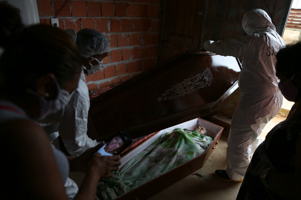 ممرضون ينقلون جثة أحد المتوفين بكورونا في ريو دي جنيرو