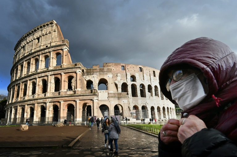 رجل يضع كمامة قرب مبنى الكولوسيوم في روما