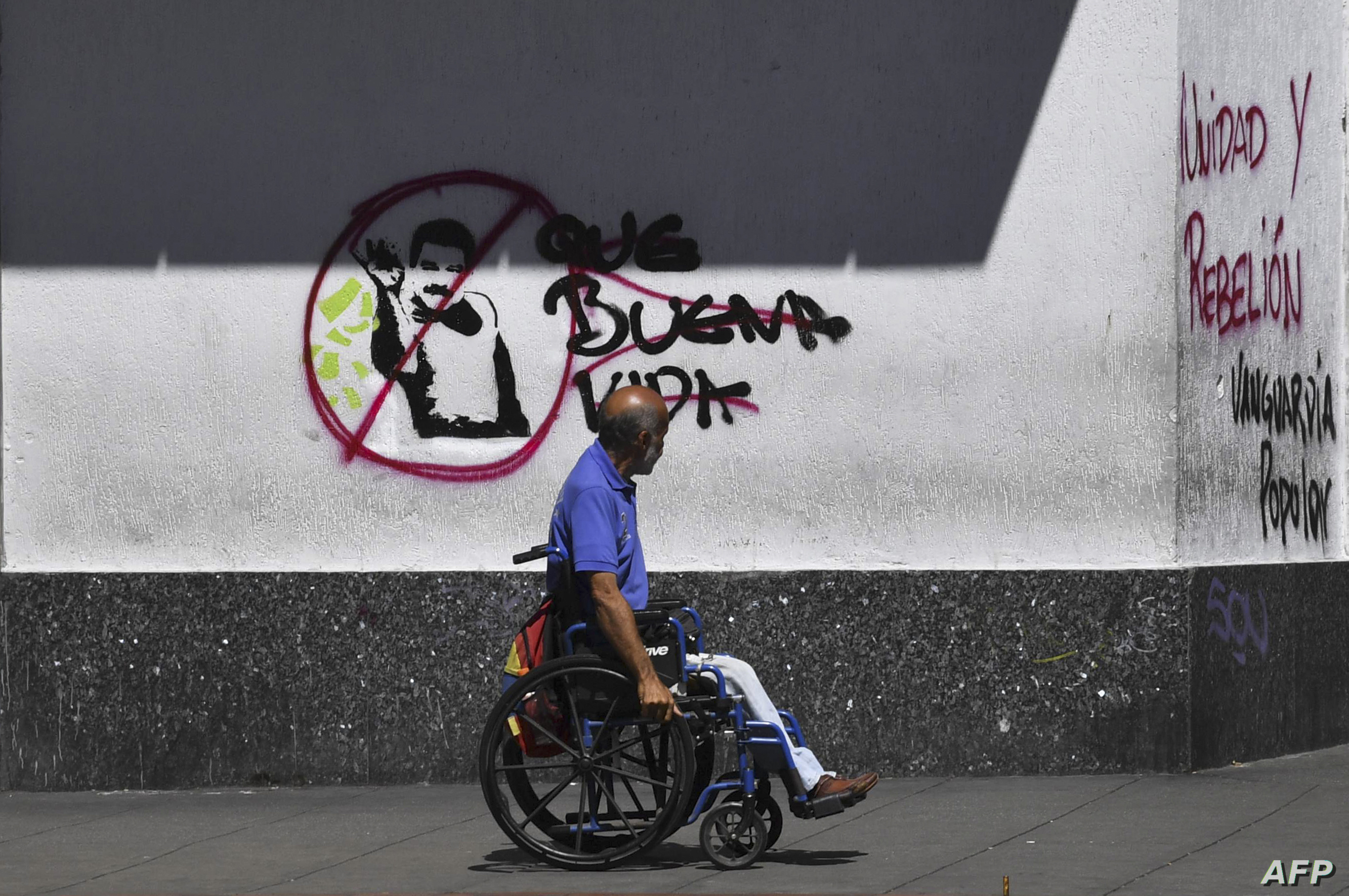 فنزويلي يمر أمام غرافيتي مناهض لمادورو في كاراكاس