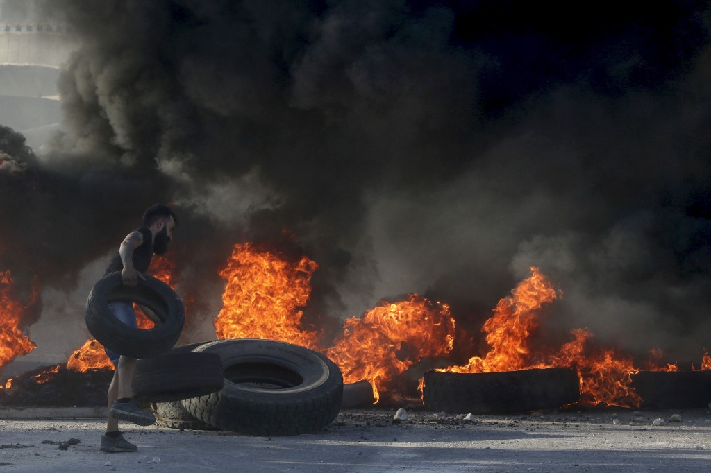متظاهر يحرق اطارات في بيروت
