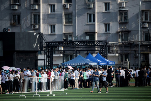 أشخاص يقيمون قرب سوق تشينفادي أو زاروها، يصطفون للخضوع لفحص الكشف عن كورونا في أحد المراكز الرياضية في بكين في 16 يونيو 2020
