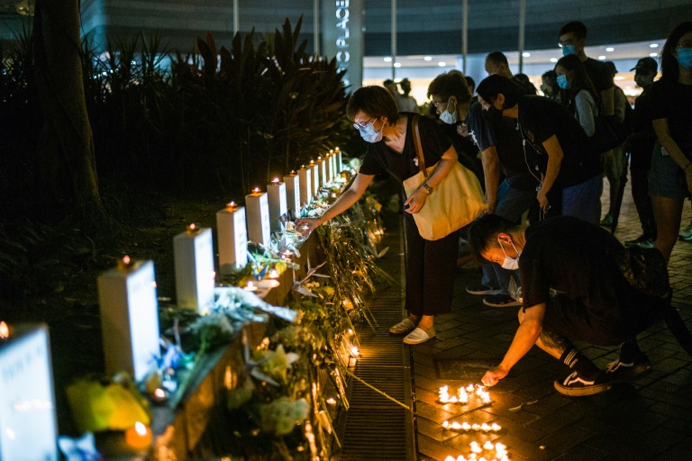 نشطاء مؤيدون للديموقراطية يشعلون شموعا في الذكرى الأولى لمتظاهر توفي خلال تظاهرة خارج مركز تجاري، في هونغ كونغ في 15 حزيران/يونيو 2020.