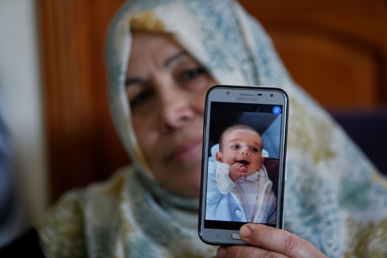 جدة الرضيع عمر ياغي الذي توفي الخميس عن ثمانية أشهر، تعرض صورته في منزل العائلة في مدينة غزة