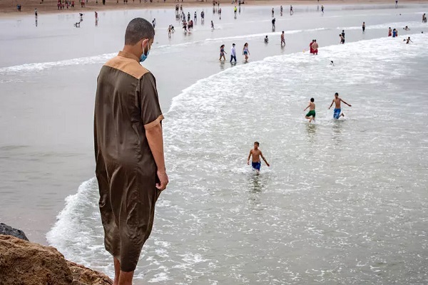 مغاربة عند شاطئ مدينة سلا الواقعة شمال العاصمة الرباط بعدما خففت السلطات القيود على النشاطات في بعض المدن