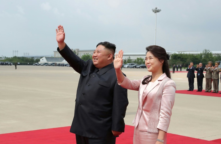 صورة نشرتها وكالة الأنباء المركزية الكورية الشمالية تظهر زعيم البلاد كيم جونغ اون وزوجته ري سول جو يلوّحان للرئيس الصيني شي جينبينغ وزوجته قبل مغادرتهما مطار بيونغ يانغ في 21 حزيران/يوني 2019.