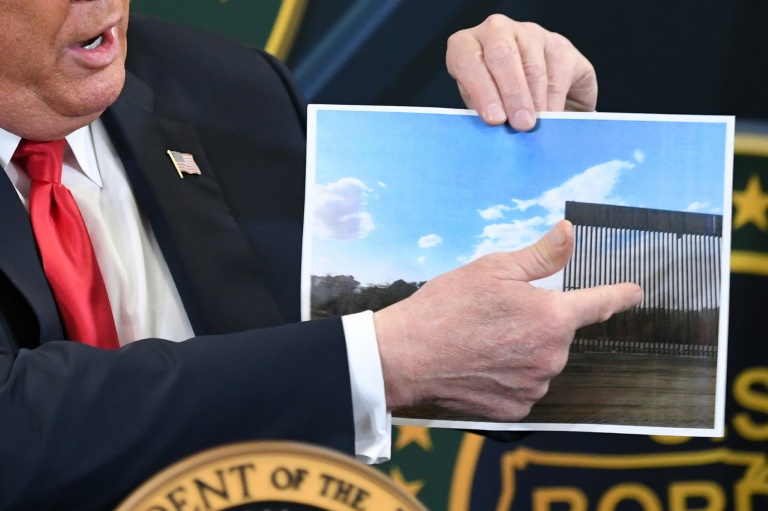 ترمب يحمل صورة للجدار مع المكسيك