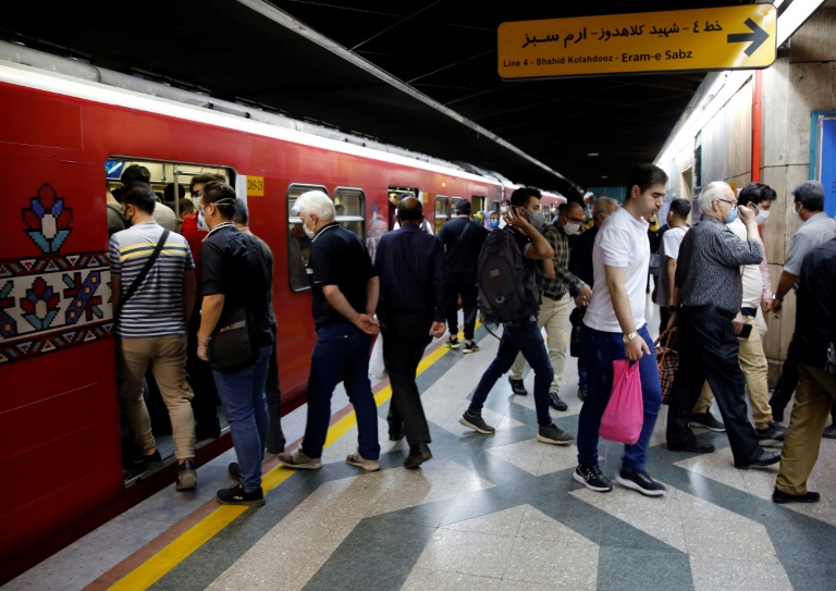 صورة لإيرانيين يضع كثير منهم الكمامات في محطة قطارات في طهران