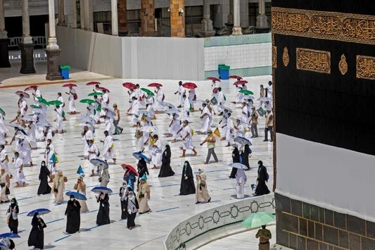 حجاج يحملون مظلات بألوان مختلفة على مسافة من بعضهم البعض في مكة المكرمة مع بدء مناسك الحج في 29 يوليو 2020