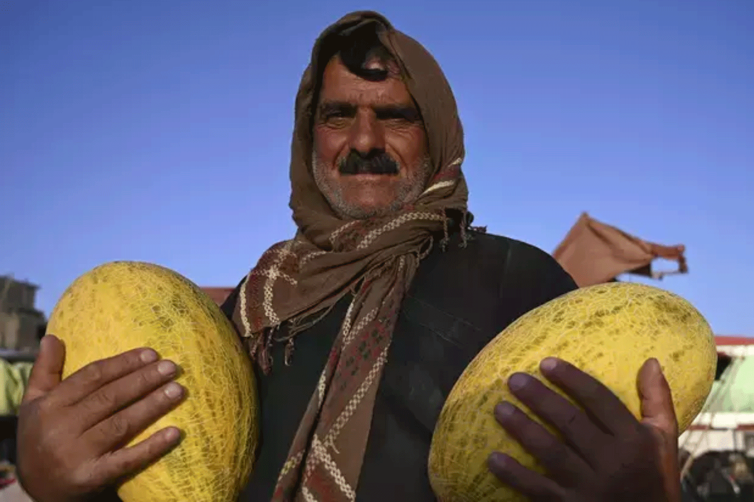 بائع يحمل البطيخ وينتظر الزبائن في سوق للفاكهة قبيل حلول الأضحى في كابول يوم 28 يوليو