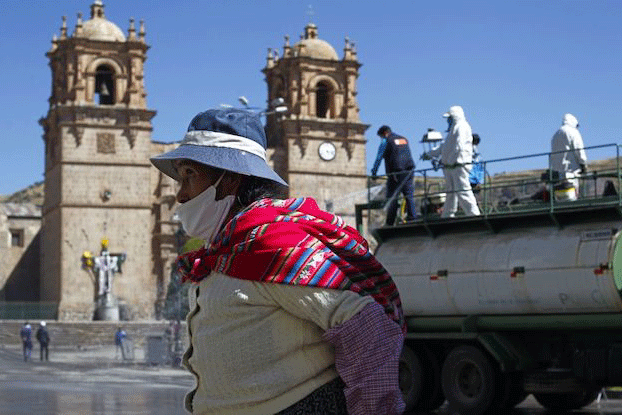العمال الصحيون يعقمون الشارع الرئيسي في بونو في البيرو