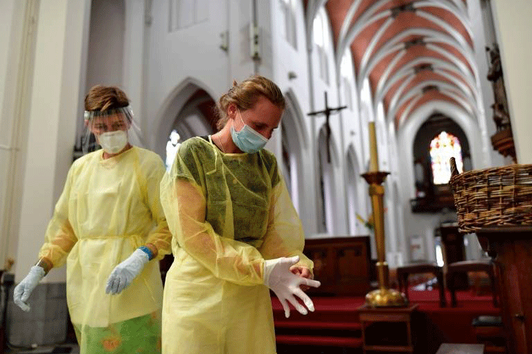 ممرضات يجهزن أنفسهن قبل البدء بفحوص الفيروس التاجي داخل كنيسة في أنتويرب، بلجيكا، بتاريخ 27 يوليو 2020