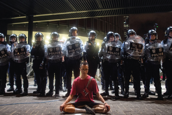 رجال شرطة يحاصرون ناشطًا يدعو لحرية الرأي في هونغ كونغ في 10 يونيو الماضي