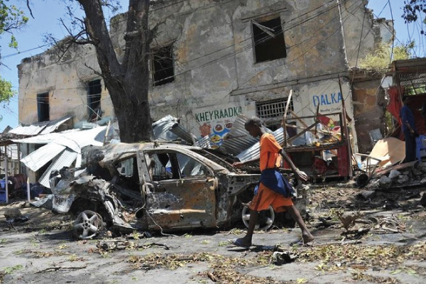 صبي صومالي يمر بموقع انفجار سيارة ملغومة في مقديشو في يوليو الماضي
