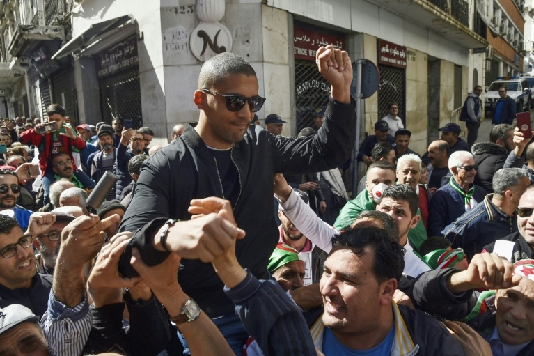 متظاهرون جزائريون يحملون الصحافي خالد درارني، 6 مارس 2020
