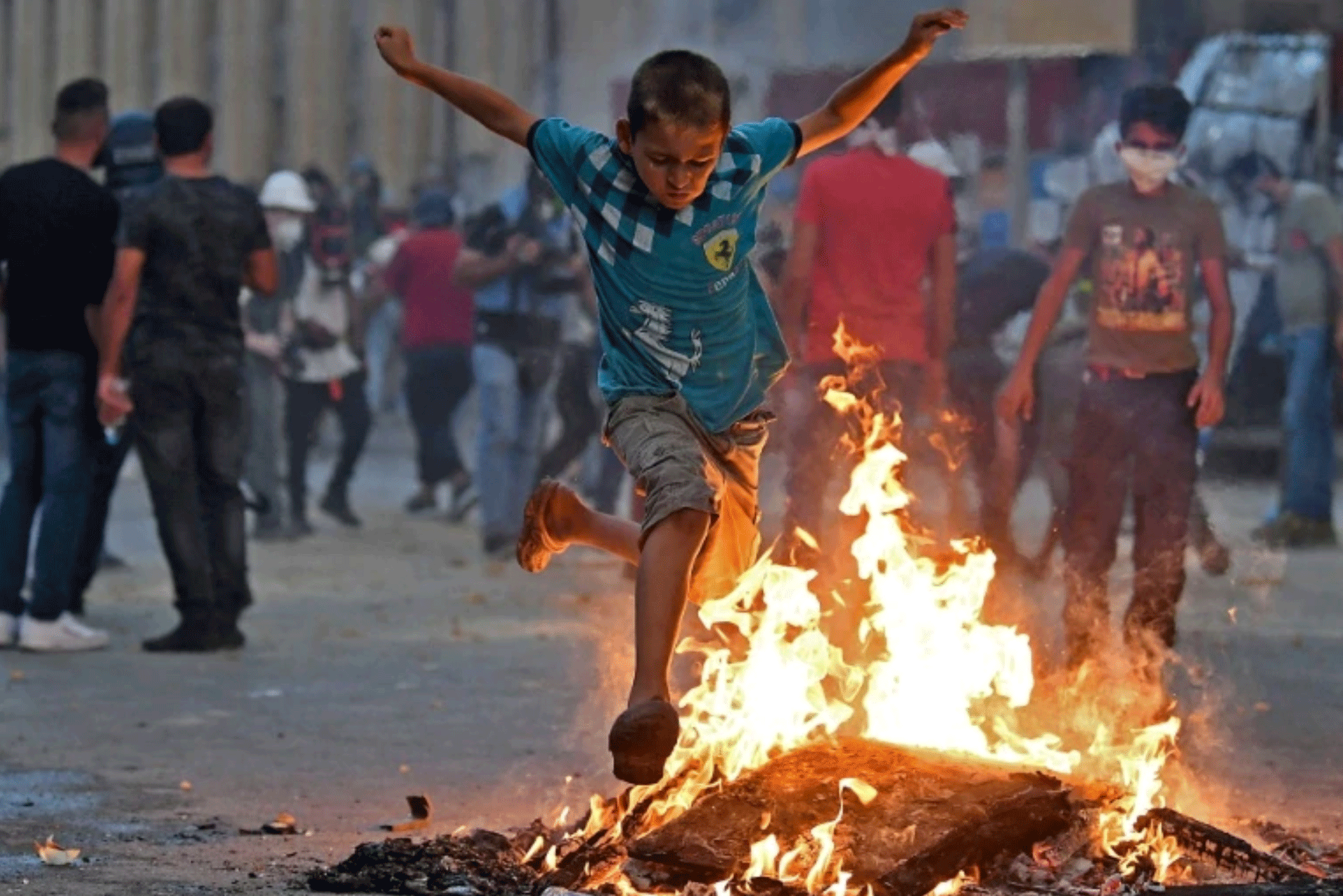 صبي لبناني يقفز فوق نار مشتعلة خلال المواجهات بين المتظاهرين والقوى الأمنية في بيروت العاشر من أغسطس 2020