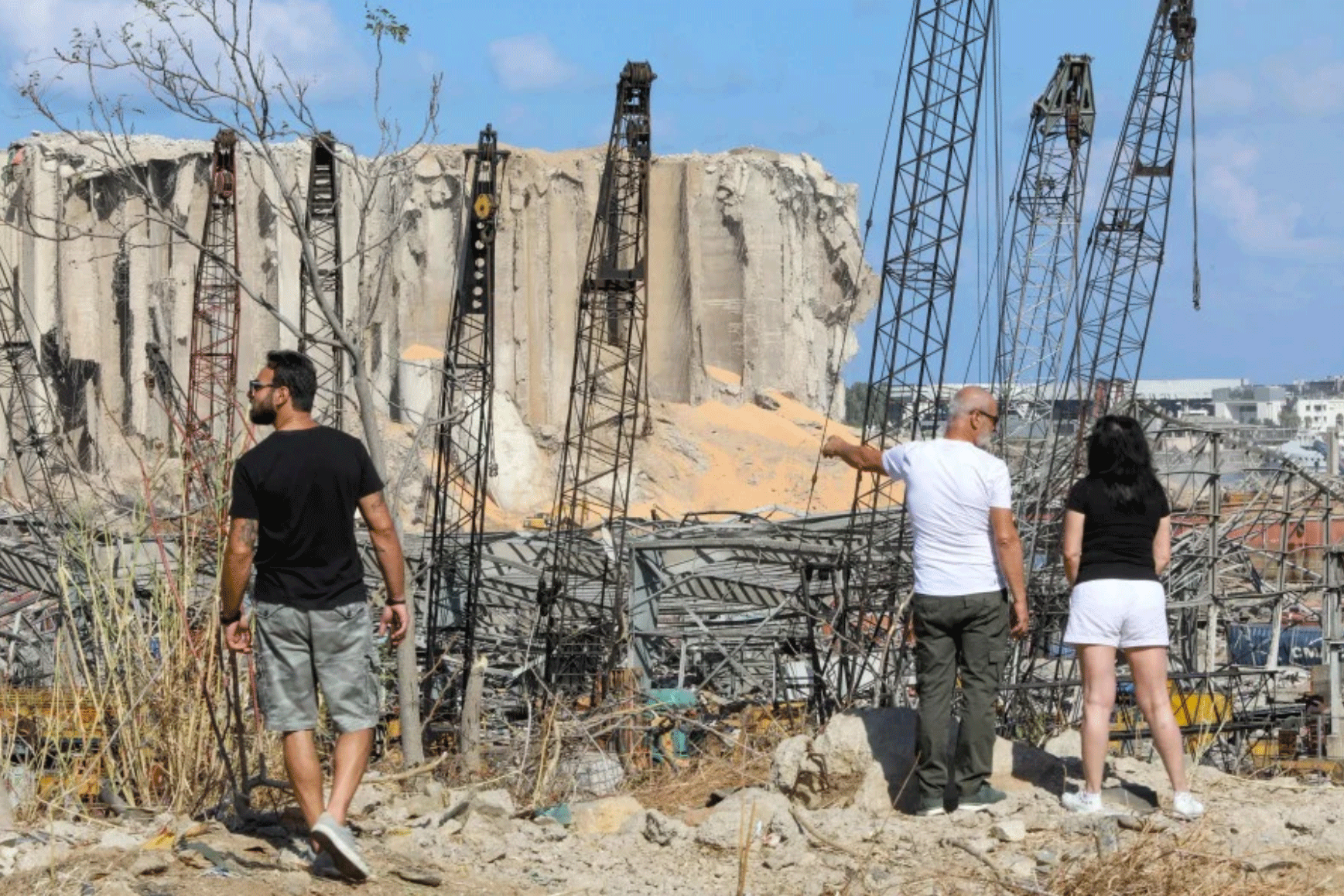 مارة يتابعون آثار الدمار الذي خلفه الانفجار في مرفأ بيروت